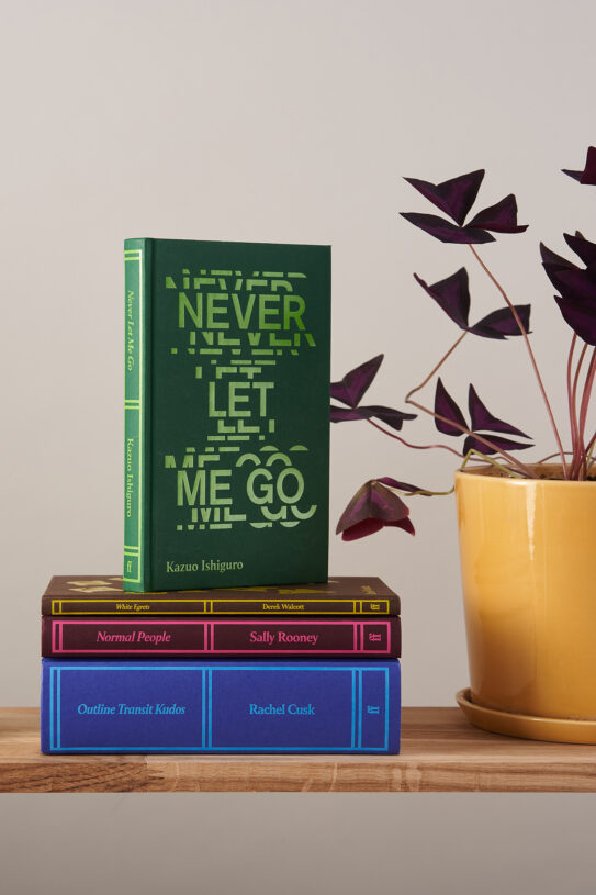 Stack of Faber Members Editions next to plant Stack of Faber Members Editions next to plant